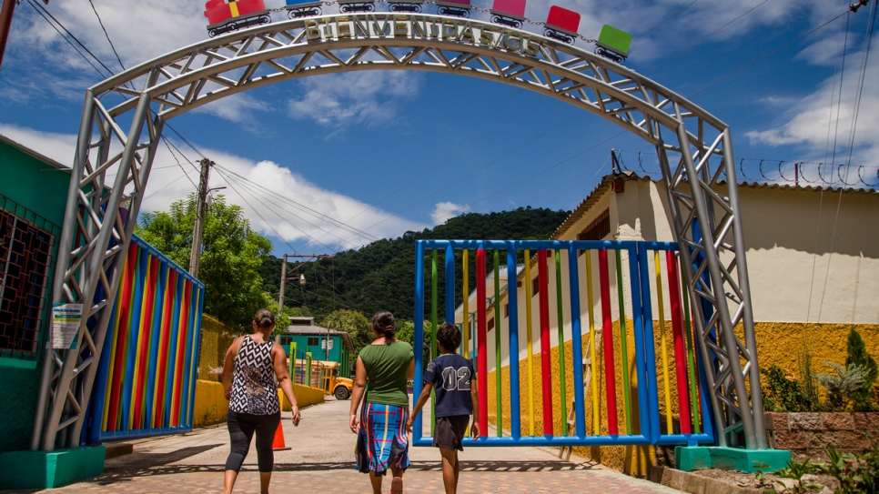 Une famille passe les portes d'un centre de jour géré par le gouvernement à Santa Ana, El Salvador, qui organise des ateliers et une formation professionnelle aux adolescents et qui fournit un espace sûr loin de la vie des gangs. 