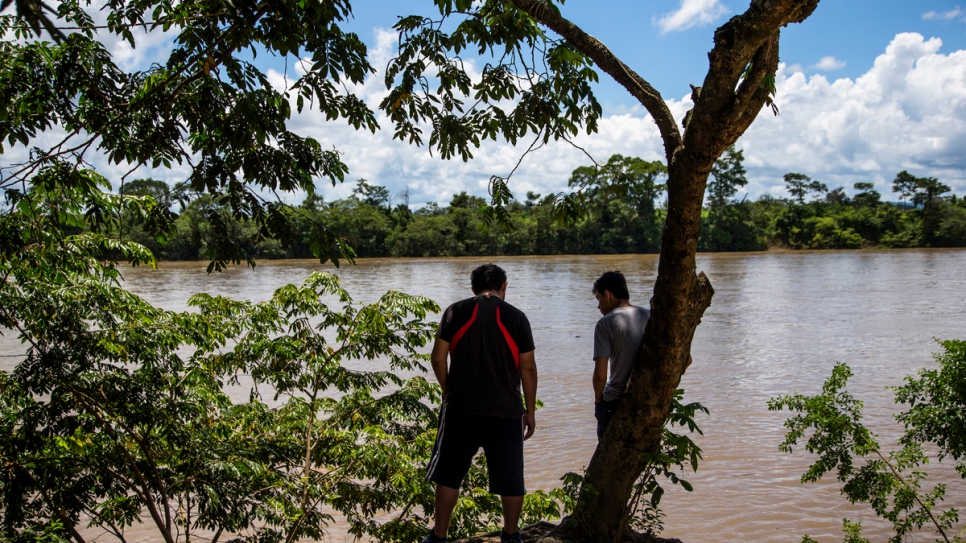 Deux jeunes Honduriens attendent sur les rives du fleuve Usumacinta à La Técnica, au Guatemala. Ils devront payer 150 quetzales (environ 20 USD) pour traverser par bateau vers le Mexique de l'autre côté. 