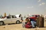 فرّ هذا الرجل من الموصل بسيارته. ويتفقّد حاجياته قبل التقدّم إلى نقطة التفتيش في الخضير حيث يأمل السفر إلى أربيل. يصل العديد من النازحين دون أية حاجيات.