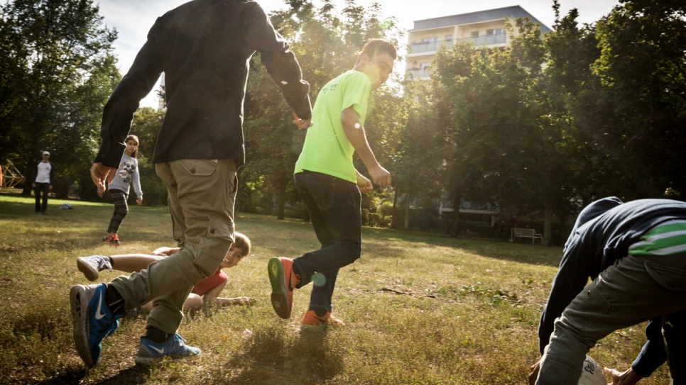Hassan et ses collègues jouent au football avec les enfants dans un parc de Berlin. 