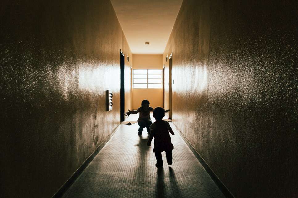 Hanan plays with her younger sister, Yara, outside their apartment in downtown São Paulo.