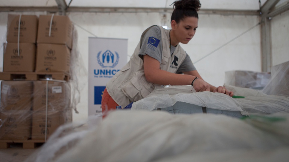 Staff unpack bundles of thermal blankets, sleeping bags and winter clothing, to be distributed to refugees staying at the open accommodation site of Eleonas in Athens, Greece.