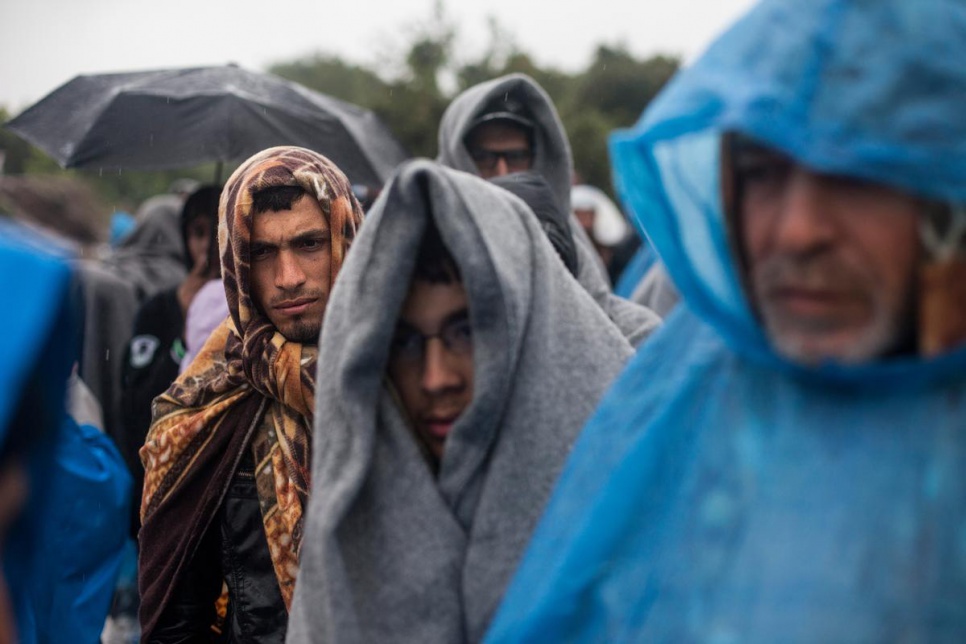 When supplies of rain ponchos run out refugees use blankets to protect themselves from the rain.