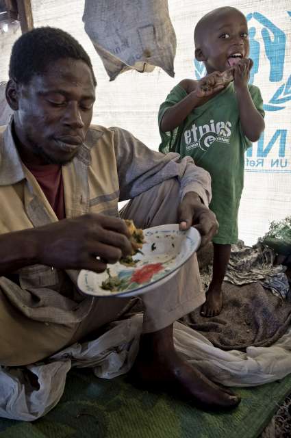 Baseme and his youngest son enjoy a meal.  