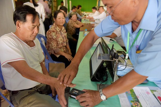 A Cambodian man scans his finger during voter registration at a commune in Kandal province, Sept. 1, 2016.