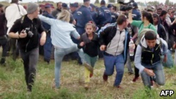 A video grab shows Petra Laszlo appearing to kick a child as she ran with other migrants from a police line during disturbances at Roszke in southern Hungary.