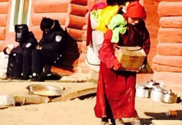 Watched by police, a Tibetan nun leaves her home at Larung Gar in an undated photo.