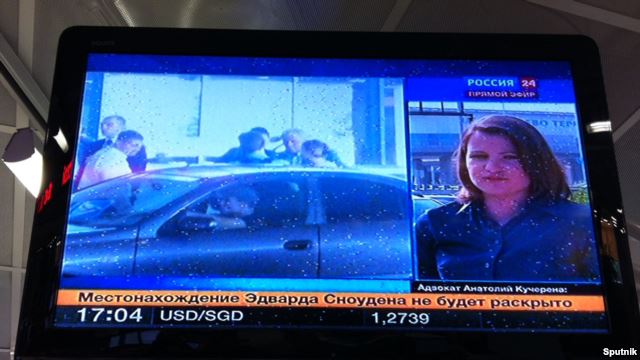 A TV screen shows former U.S. intelligence analyst Edward Snowden leaving a Moscow airport on August 1.