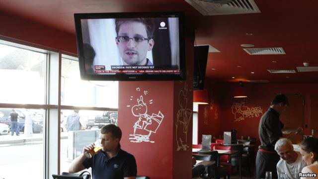 A television shows former U.S. intelligence contractor Edward Snowden during a news bulletin at a cafe at Moscow's Sheremetyevo Airport.