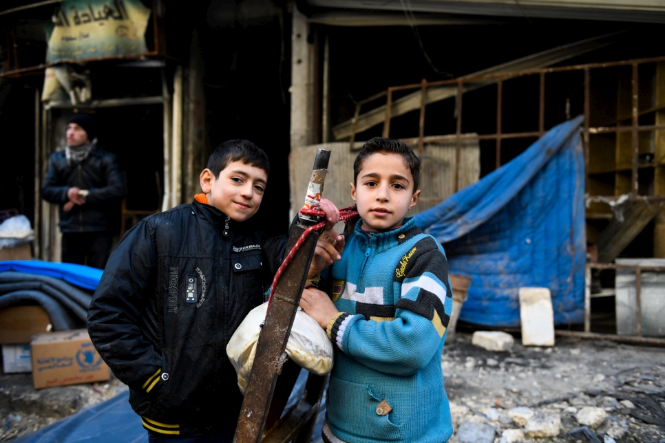 Des enfants posent devant un bâtiment détruit dans le quartier d'Al-Mashatiyeh, à Alep-Est.