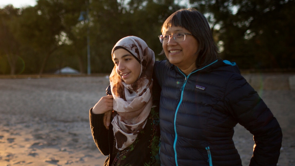 Thuy Nguyen and Narjes Nouman spend time at a beach in downtown Toronto. Nguyen arrived as a refugee more than 40 years ago and now serves as a mentor to newly arrived Narjes.
