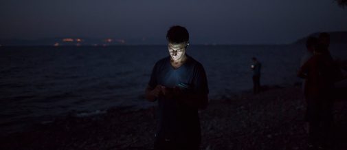 Syrian refugees who just landed on the Northern shores of Lesbos Island from Turkey try get mobile phone receptions so that they can check their location and notify relatives that they arrived safely. UNHCR/Ivor Prickett