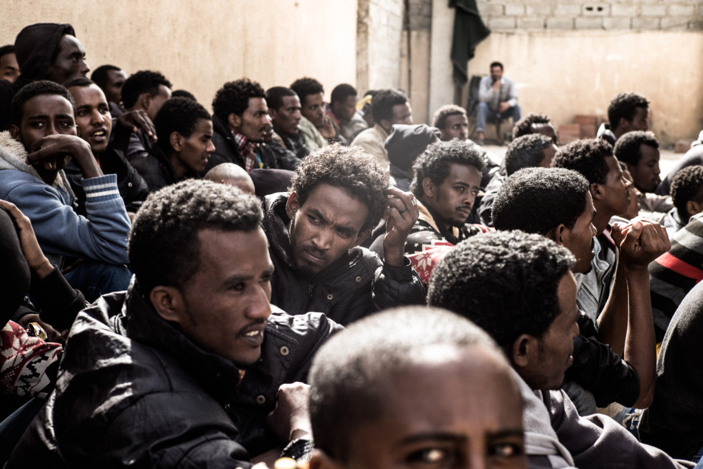 Eritrean refugees and migrants sit in a detention center during a roll call, Subrata, Libya, April 21, 2014. ©http://www.danieletter.com/