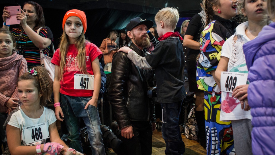 Gesha talks with his son Ivan, who is attending a dance competition.