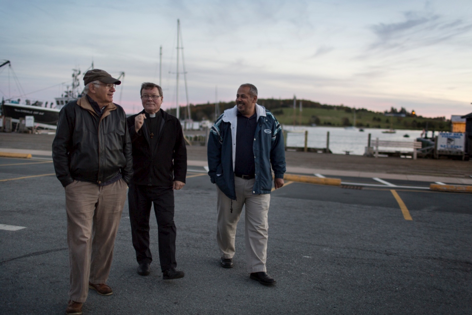 David Friendly (à gauche) et le père Michael Mitchell passent du temps avec Ahmad Ayash sur la jetée de Lunenburg.