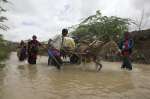 Des réfugiés somaliens fuient les inondations à Dadaab, au Kenya. Les camps de réfugiés de Dadaab sont situés dans des zones prédisposées à la fois aux inondations et à la sécheresse. De ce fait, la survie des réfugiés et la fourniture d’une assistance par le HCR constituent une véritable gageure. 