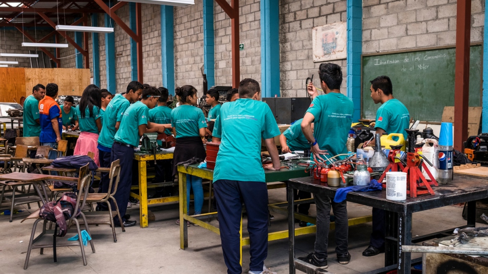 Un groupe de jeunes apprend à réparer un moteur lors d'un atelier de mécanique automobile dans un centre communautaire et pour les jeunes, qui est géré par le gouvernement, à Santa Ana, au Salvador. 