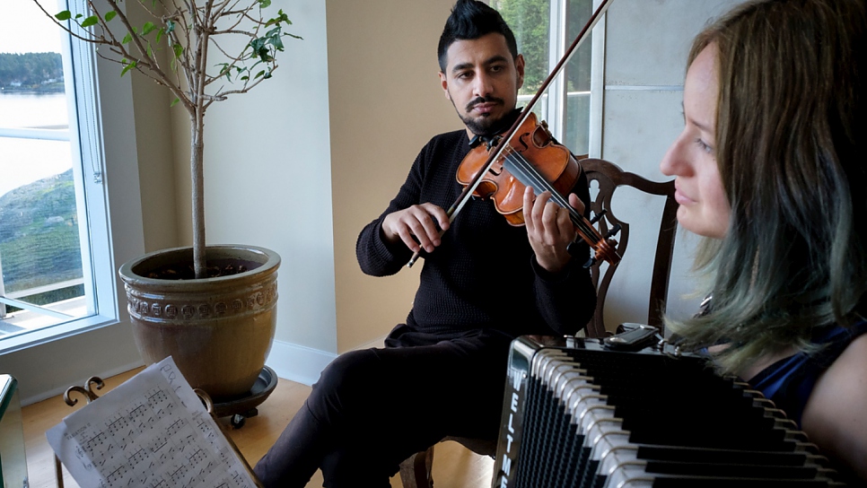 Sari joue du violon tandis que la fille de Paulina, Julia, joue de l'accordéon. 