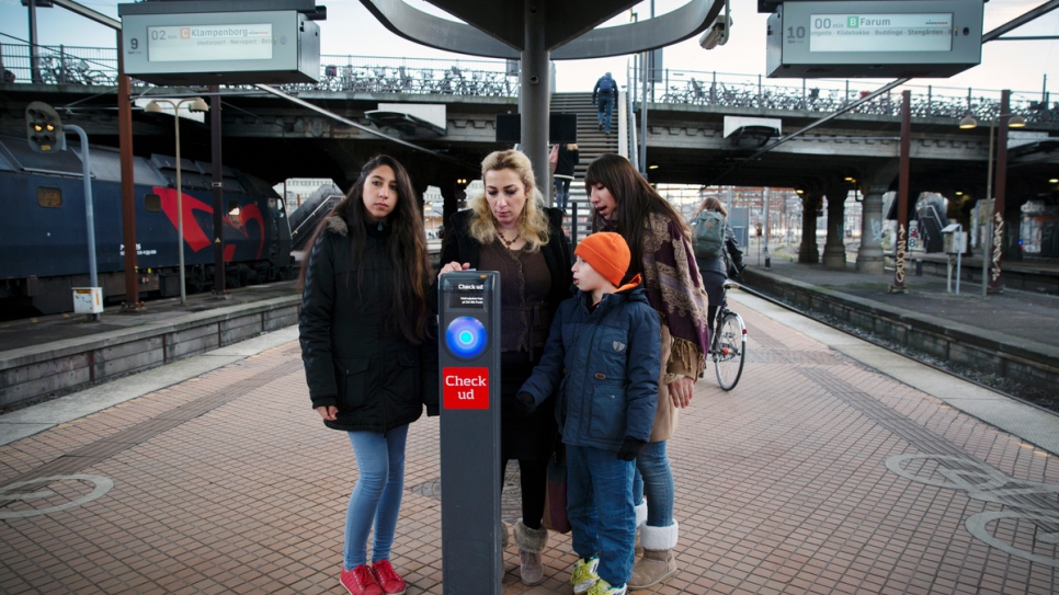 La famille achète des billets de train de retour vers leur appartement. 