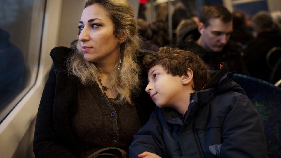 Manal dans le train avec son fils Karam, âgé de huit ans. 
