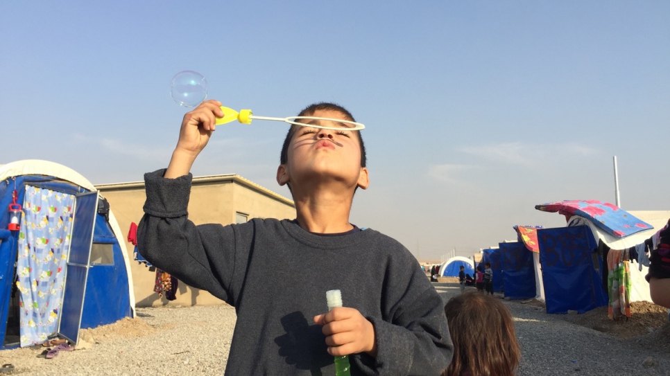 Un jeune garçon souffle des bulles dans un camp de déplacés internes iraquiens près du village de Hasansham, à 30 kilomètres de Mossoul. 