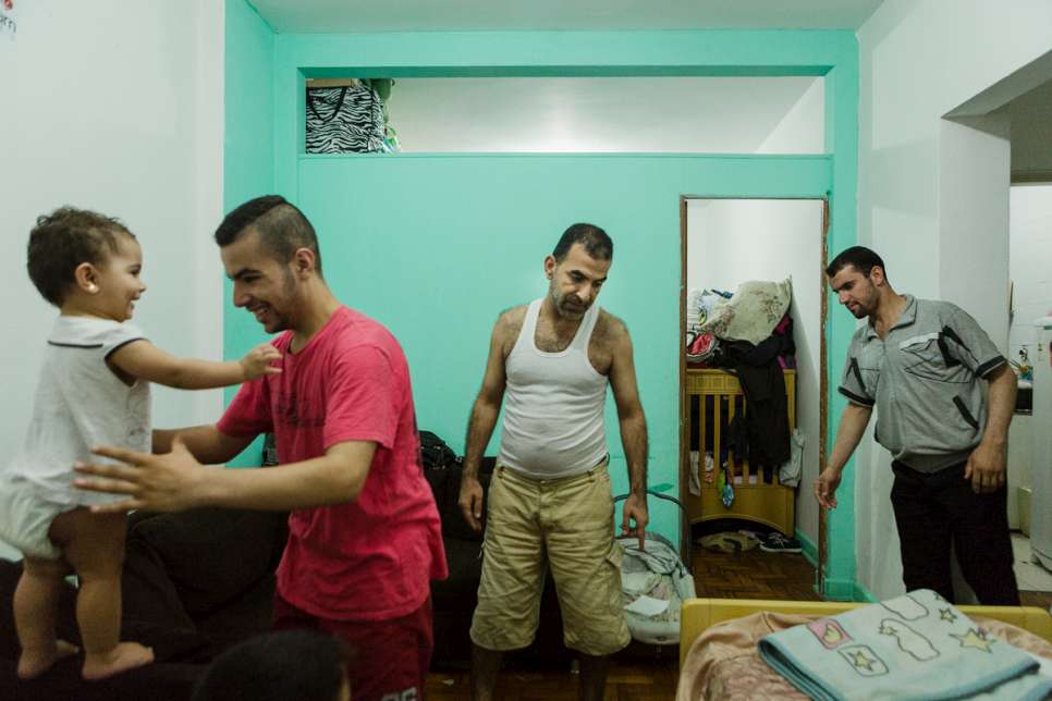 Moustafa plays with his younger sister while Khaled and Zaher prepare the room for sleeping.