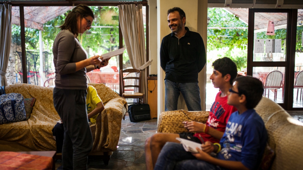 Andreas Vasileiou, the owner of Hotel Rovies, takes part in a French language class taught to young boys from Syria.