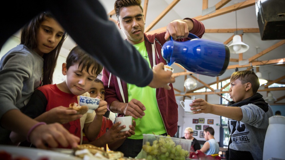 The children eat with Hassan and his colleagues at a nearby youth club. 