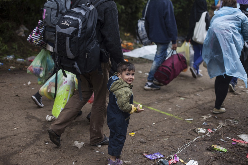 Refugees carry bags filled with supplies they received from volunteers in Bapska, Croatia.