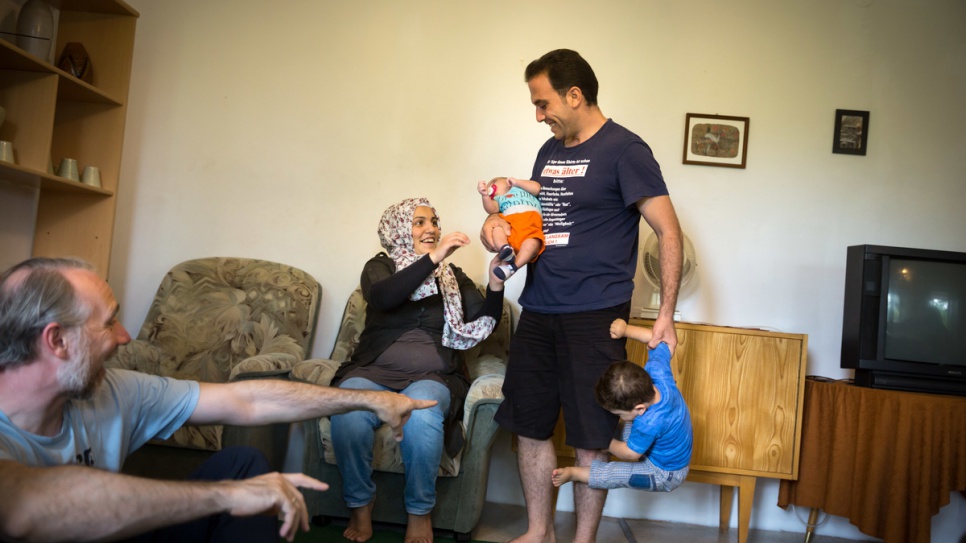 Fatima and her husband Moufid play with their children in their new home in Röhrsdorf, Germany.