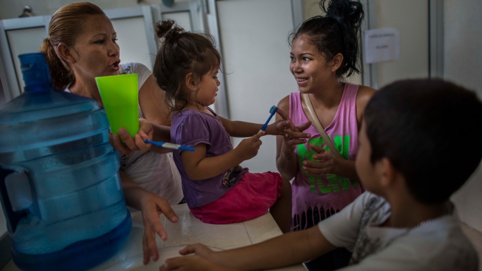 Brenda and Eric help the children to brush their teeth at a daycare center.