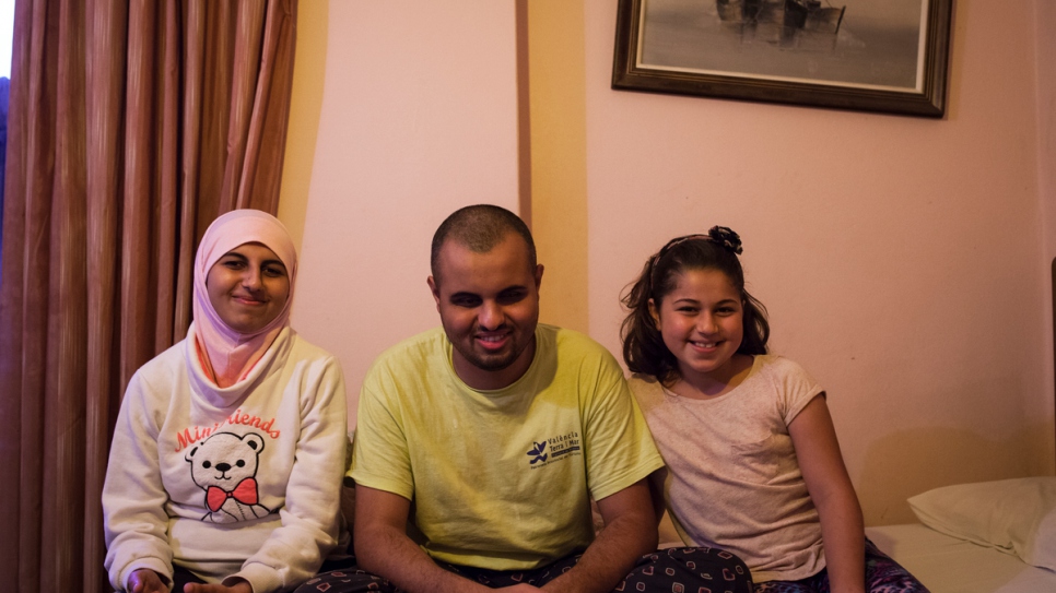 Ashraf, who is blind, sits with his sisters Ghufran and Salam inside the room they share at the Rovies Hotel.