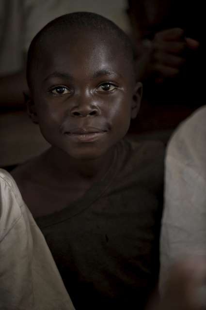 Sukuru, 10 ans, photographié à Mugunga III quelques mois après avoir fui le village natal et s'être trouvé séparé plusieurs jours de ses parents. Le garçonnet, dont le nom signifie « merci » en swahili, raconte qu'avec ses souliers usés, il n'avait pas pu suivre le mouvement. Il espère que l'école reprendra bientôt dans le camp, de manière à continuer de recevoir une instruction malgré la situation instable.