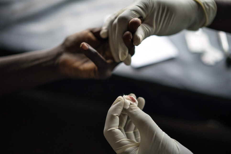 Dominique* undergoes a blood test for sexually transmitted diseases at the Manono general hospital, after being admitted following an interview by UNHCR's partner IEDA.