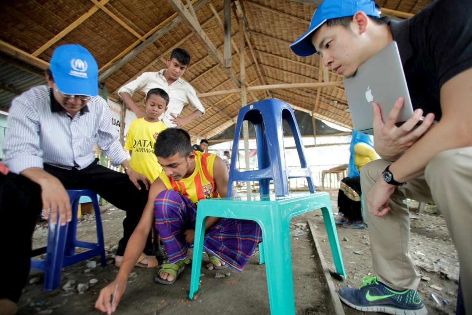 Kasim explains to UNHCR's maritime movement monitors where he was kept on a smugglers' boat. Indonesian fishermen rescued him when the vessel started sinking. 