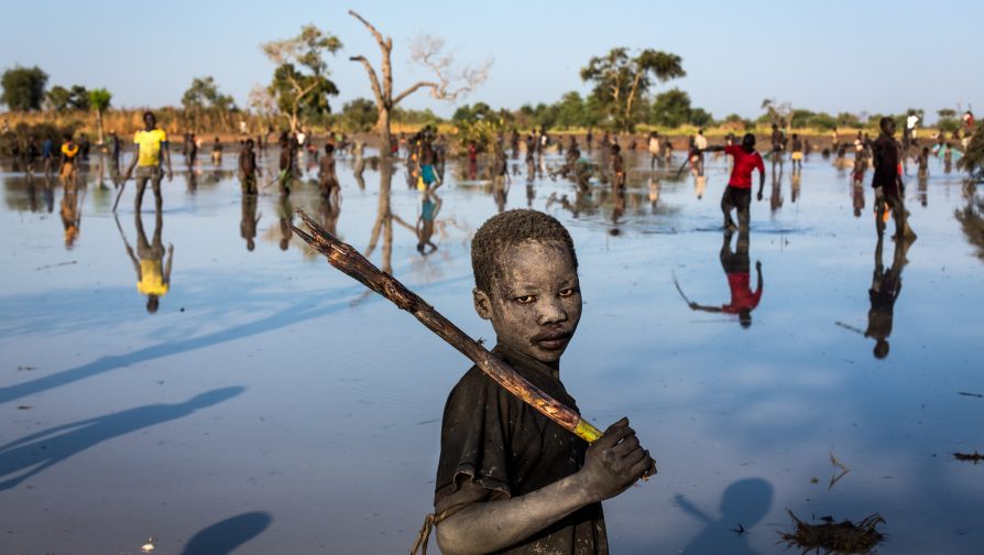 South Sudan / Sudan Refugees / Yacob Ibrahim, 10, from the Nuba Mountains in Sudan fishes in a lake formed by flood water near the town of Yida, in South Sudan. Yida is situated only a few kilometres from the Sudanese border and has become home to thousands of Sudanese refugees fleeing fighting in the border states as well as to 17,000 IDP’s fleeing fighting between government troops and anti-government rebels within South Sudan. Yacob says, "This is a job for me, I do it to buy pens and exercise books for school." With few resources many refugee children and internally displaced South Sudanese children have turned to fishing, both as a source of food and also as a source of income. Income that some of the children use pay for school items such as stationary and fees. UNHCR / A. McConnell / November 2014