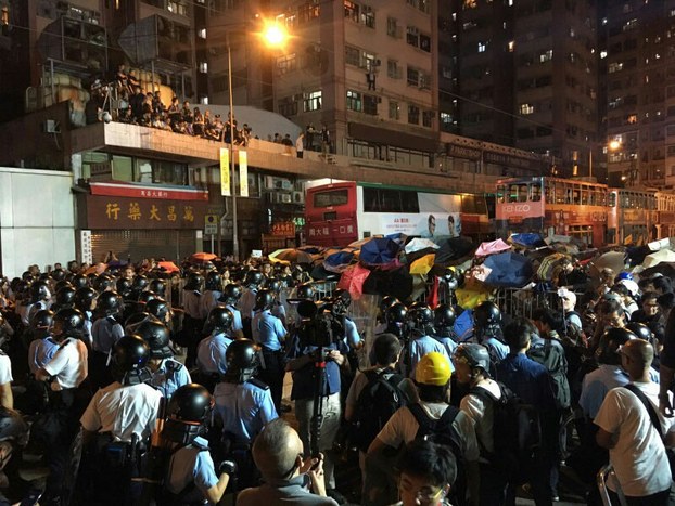 Protesters march in Hong Kong against a planned interpretation of the city's mini-constitution by China's parliament using umbrellas to ward off pepper spray attacks, Nov. 6, 2016.