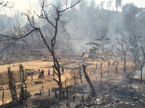 Karenni refugees survey the damage from a fire that burned down their homes in eastern Myanmar's Kayah state, April 7, 2015.