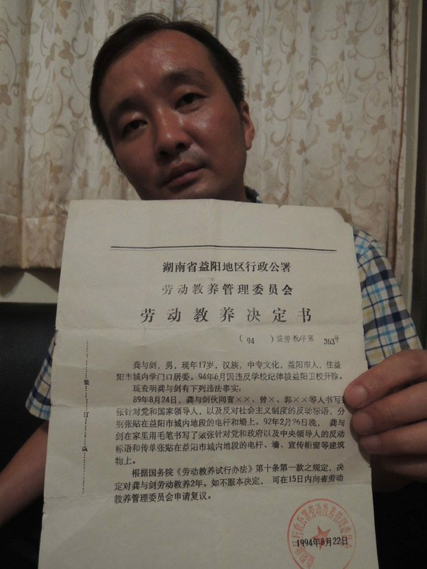 Chinese activist Gong Yujian displays a document from his 1994 imprisonment in undated photo