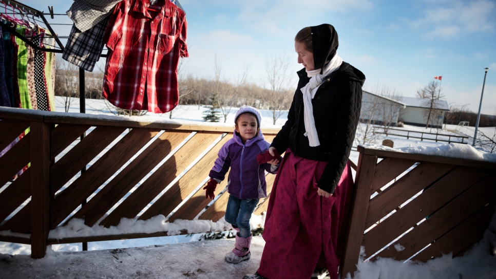 Elaine Hofer takes Raghad Al Hamoud back into the house to warm up after tobogganing with other children at the Hutterite colony.