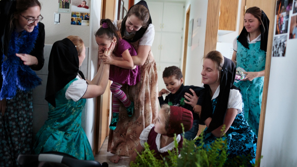 Members of the Hutterite community play with Raghad (left) and Ali.