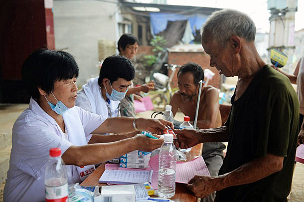 A medical professional distributes medicine to a villager in the Hehui community of Xingtai, northern China's Hebei Province, July 24, 2016.