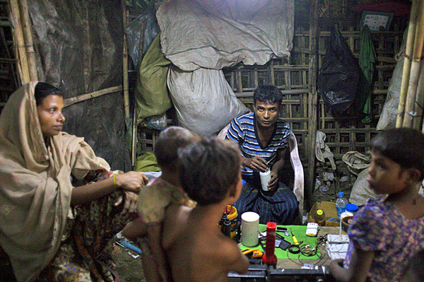 A Rohingya man, woman and children gather in a shop in the Thel-Chaung displacement camp in Sittwe, eastern Myanmar's Rakhine state, Nov. 8, 2015.