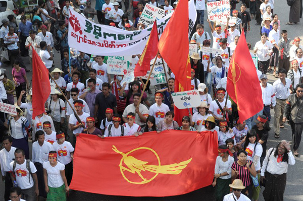 Myanmar students hold placards and flags as they march in protest against the National Education Law in Yangon, Feb. 8, 2015.