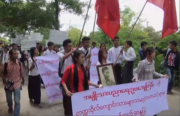 Students in Myanmar march with banners and flags to protest the National Education Bill.
