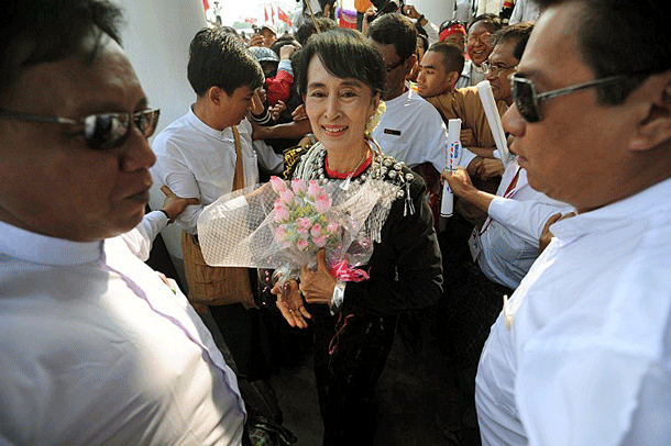 Myanmar's Aung San Suu Kyi (C) is escorted by bodyguards during a visit to Myitkyina, capital of northern Myanmar's Kachin state, Feb. 24, 2012.