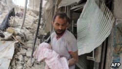 A Syrian man carries a dead baby retrieved from under the rubble of a building following an air strike on the Al-Muasalat area of Aleppo on September 23, 2016.