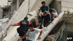 Syrian men remove a baby from the rubble of a destroyed building following a reported air strike in the Al-Qatarji neighborhood of the northern city of Aleppo on September 21.