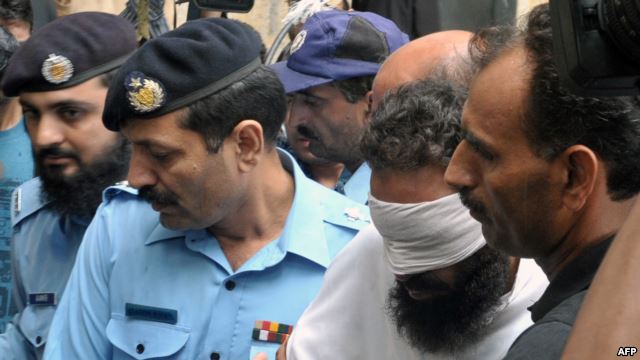 Pakistani policemen escort Islamic cleric Khalid Chishti upon his arrival at a court in Islamabad on September 2.