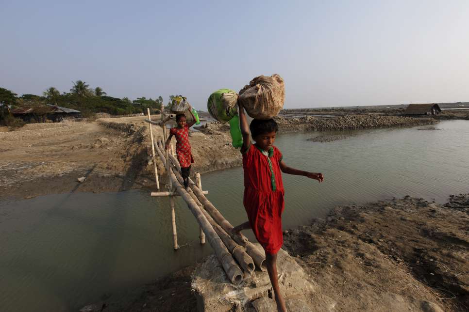 Bangladesh. Climate displaced people in Cox's Bazar.

Even 20 years ago Taplur Char in Kutubdiawas a fertile green land. Farmers used to grow paddy here. But now everything has changed as the land is now taken over by the sea. Now nothing can grow here other than salt.

Two young girls crossing a tiny bamboo bridge.